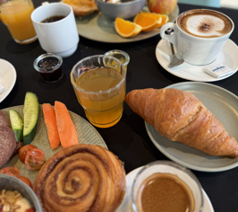 Breakfast buffet with bread, fruit and drinks