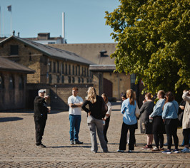 Guide fortæller engageret til en gruppe.