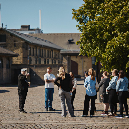 Guide fortæller engageret til en gruppe.