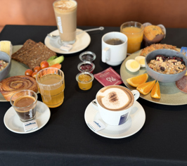 Breakfast buffet with various dishes and drinks