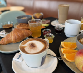 Cup of coffee with breakfast including bread and fruit