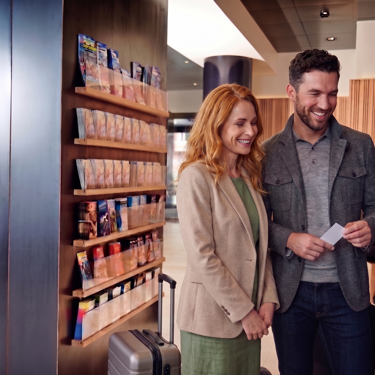 Par står i lobby og venter på elevator 