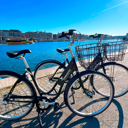 Bicycle with a basket parked by the harbour in the sunshine