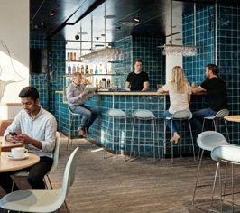 Guests sitting in a bar area with drinks in a modern café