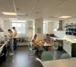 Guests cooking and dining together in a bright shared kitchen