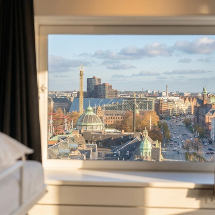 Hotelværelse med udsigt til Tivoli og Rådhustårnet gennem vinduet